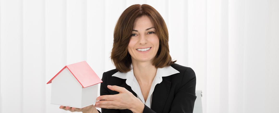Woman holding model of property in hand